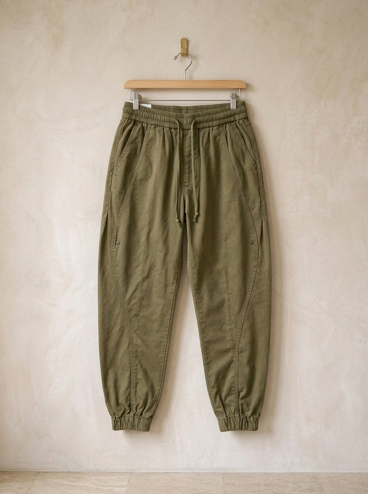 Verde | Calça jogger de algodão Guimarães verde – peça sozinha, no cabide de madeira