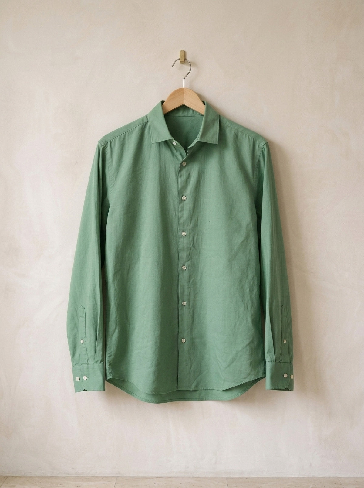 Verde | Camisa lisa manga longa Kilkenny verde – peça sozinha, no cabide de madeira