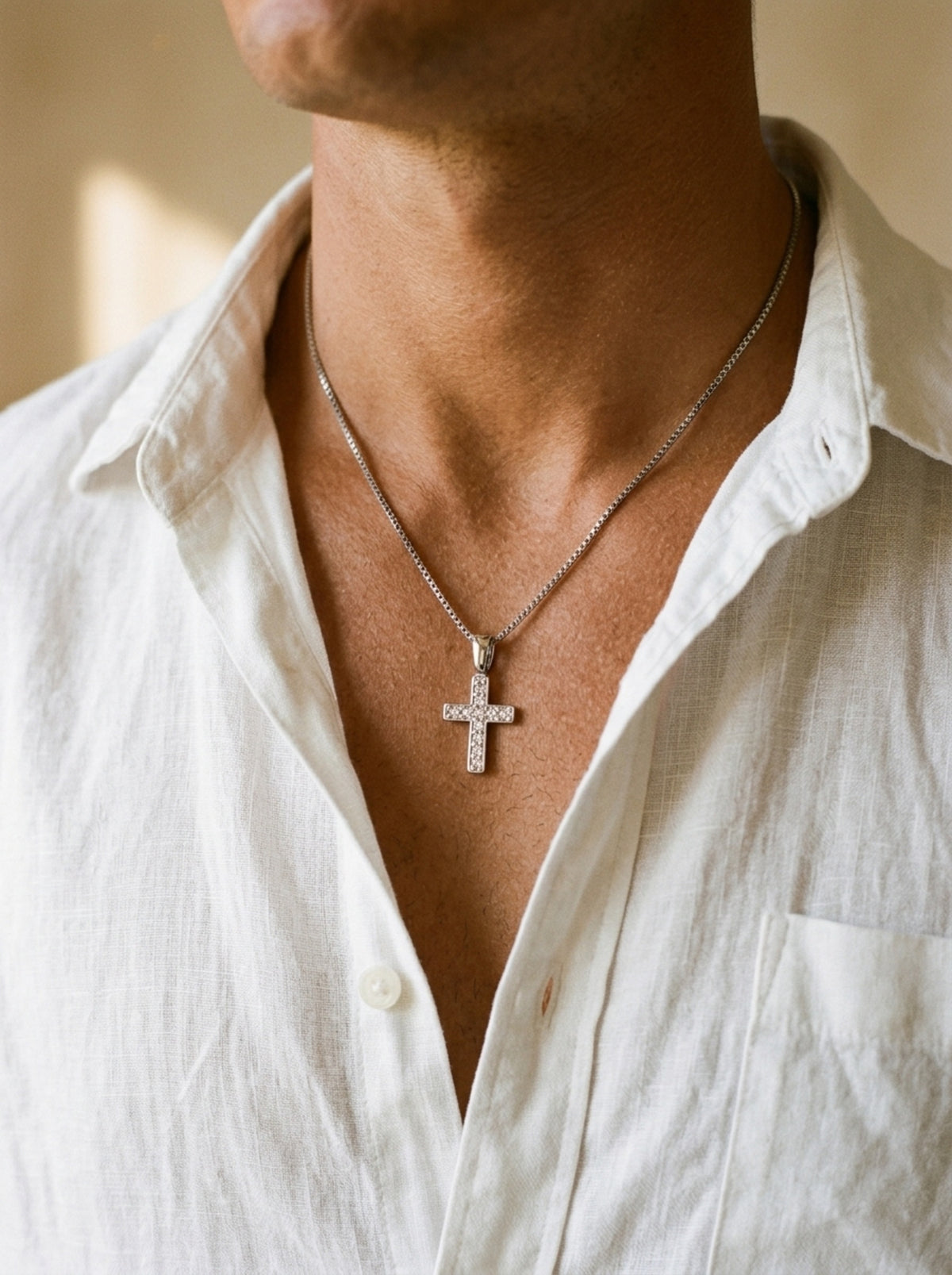 Prata | Colar de cruz com zircônias Praiano – no pescoço, com camisa de linho branca de gola aberta