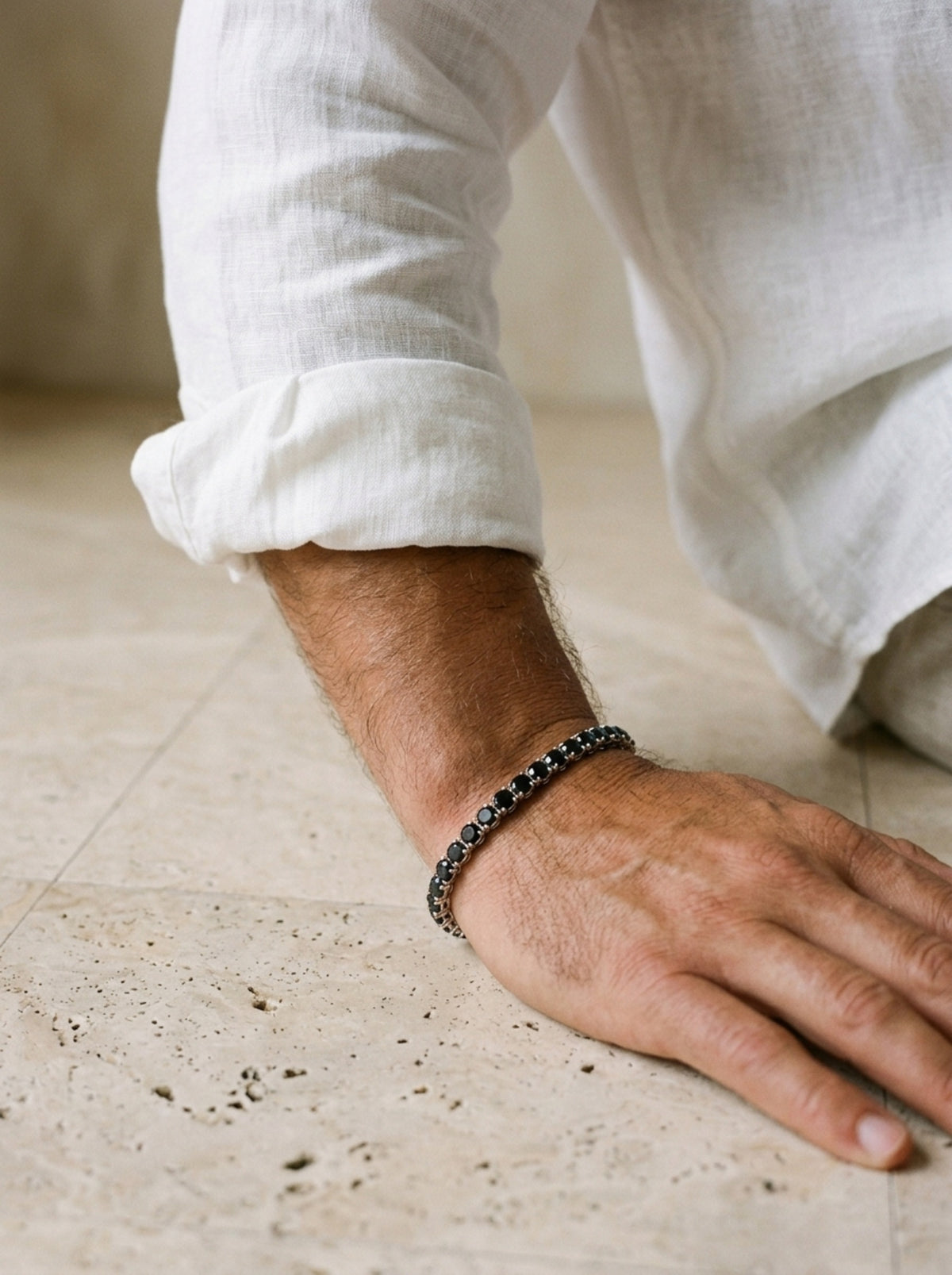 Zircônia negra | Pulseira riviera de zircônia negra Ravenna – no pulso, com punho de camisa de linho branca