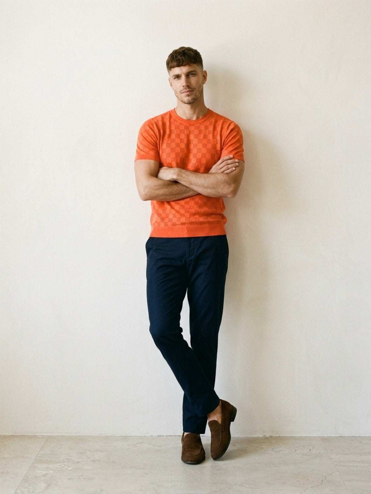 Laranja | Camiseta de tricô Sartong Svolvær laranja – modelo encostado na parede