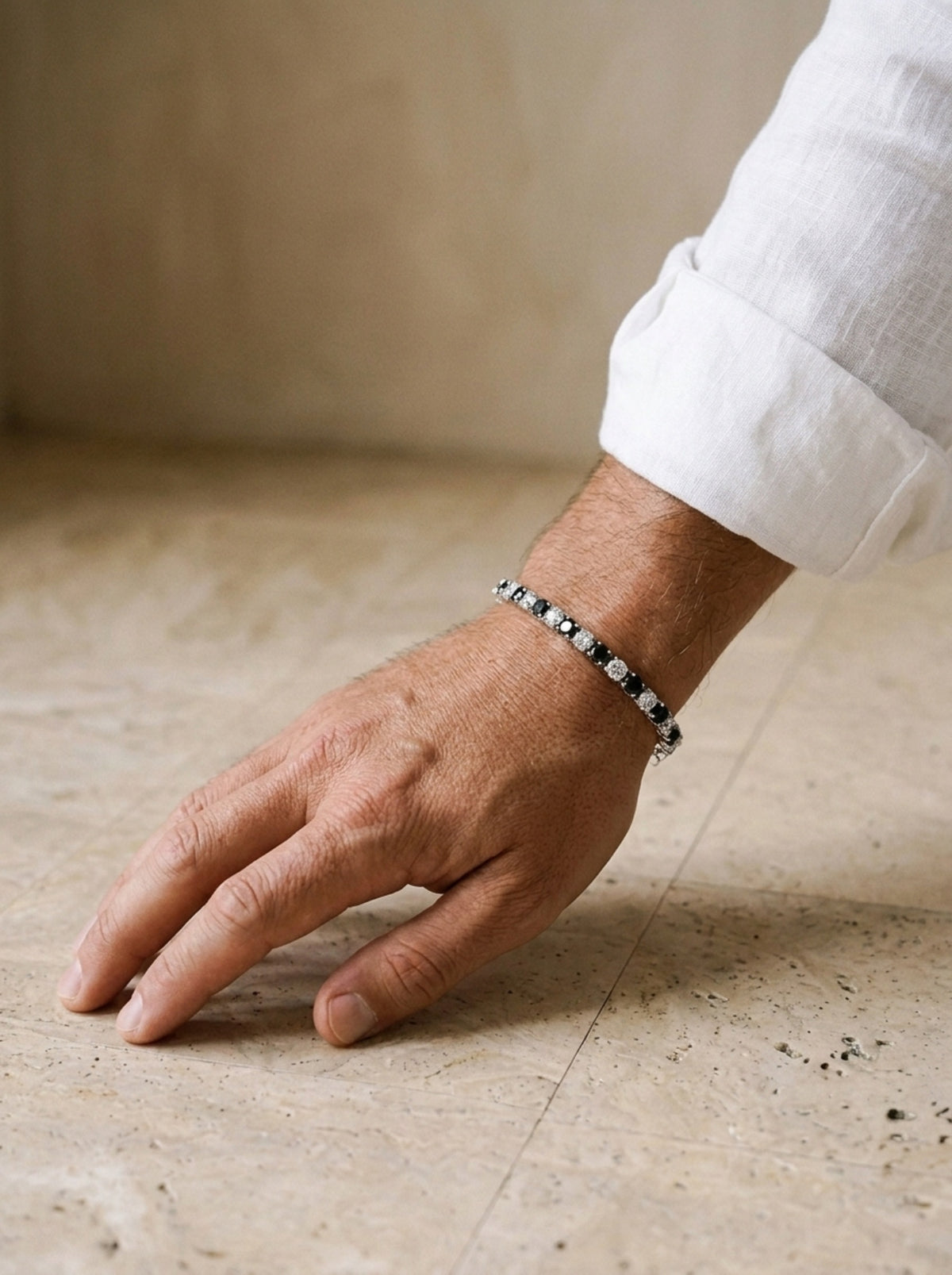 Prata | Pulseira riviera de moissanite preto e branco Syros – no pulso, com punho de camisa de linho branca