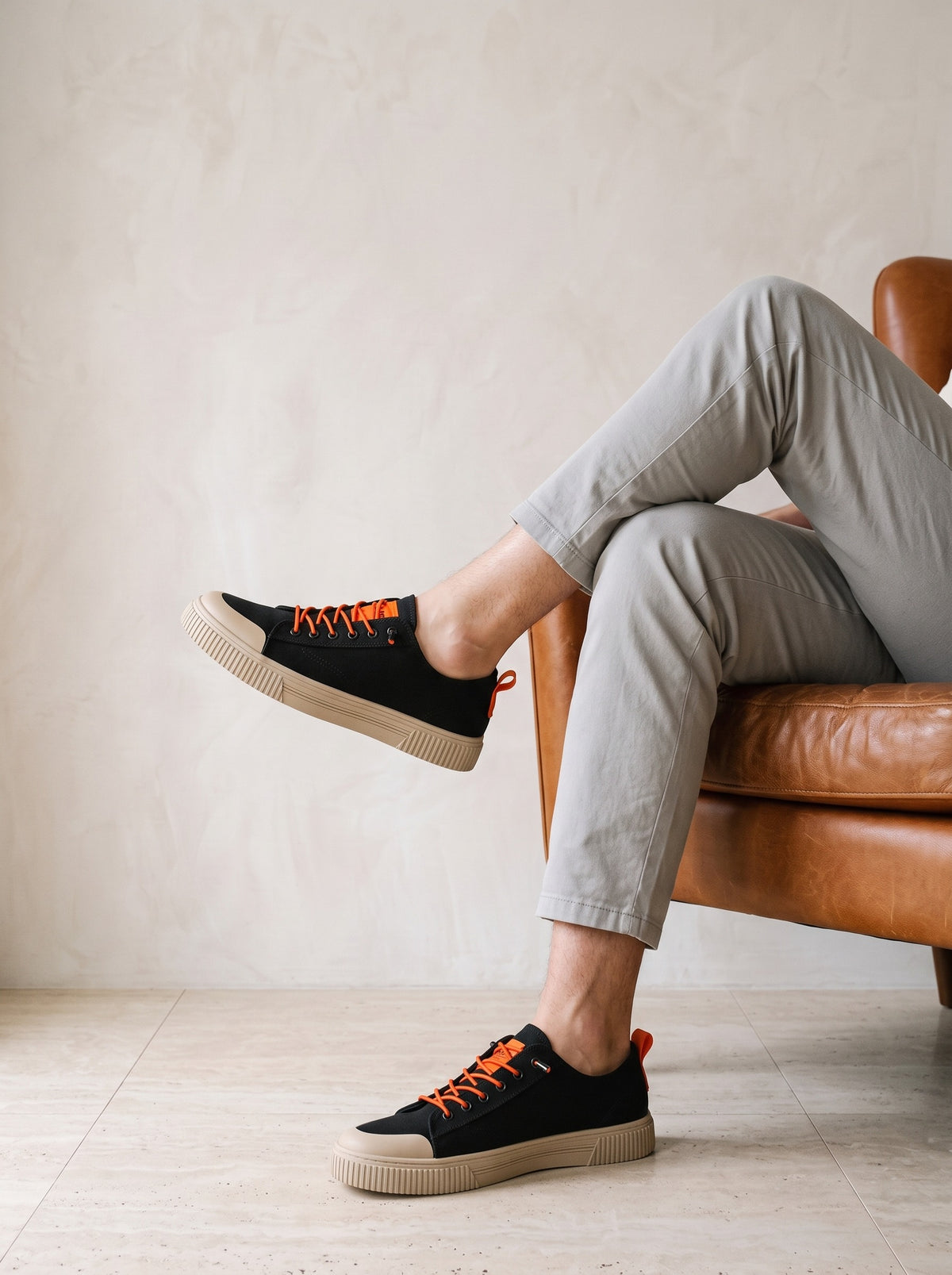 Preto com laranja | Sapatênis de lona Varna preto com laranja – look com o modelo sentado