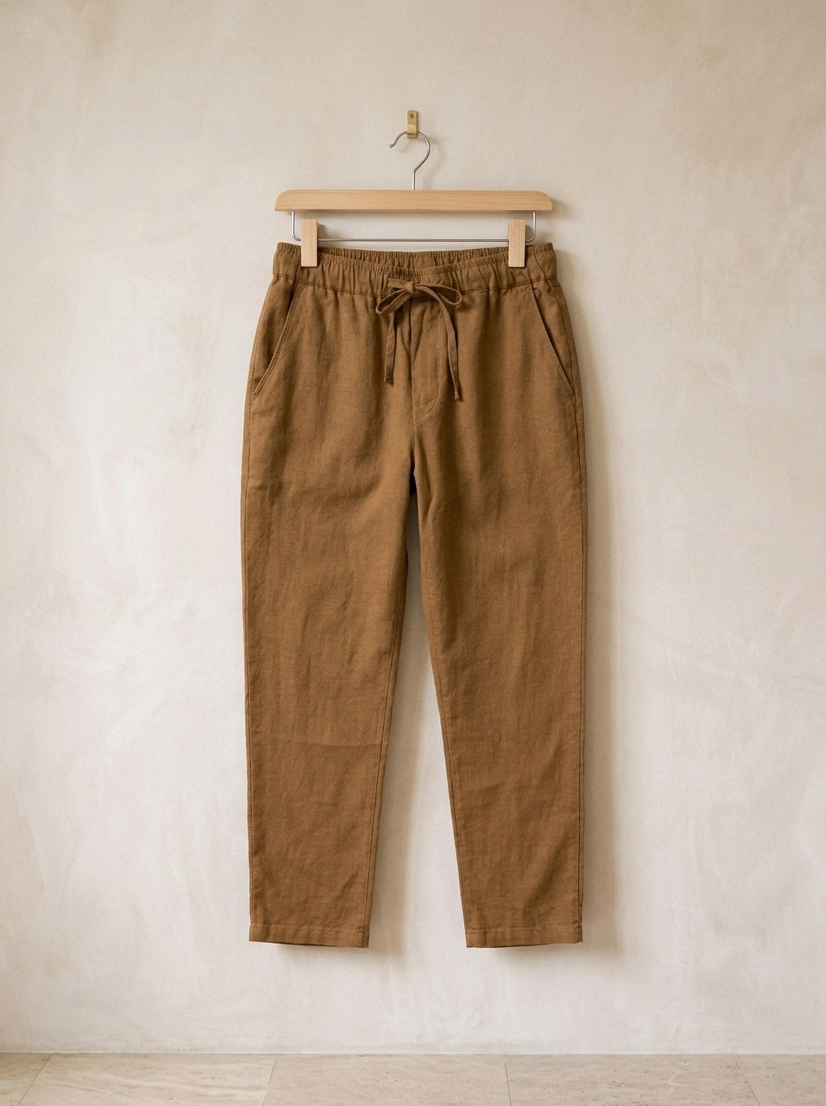 Caqui-escuro | Calça de linho Viena caqui-escuro – peça sozinha, no cabide de madeira